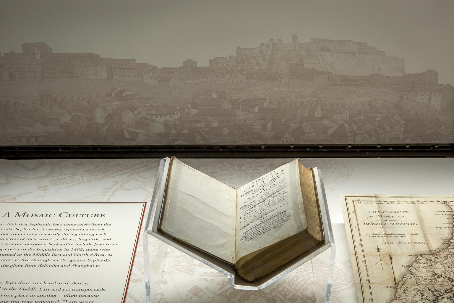 An open Bible on display in front of an ancient city